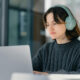 Woman with headphones on working on a laptop